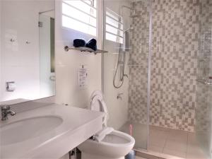 a bathroom with a tub and a toilet and a shower at Sipadan Inn Service Apartments Semporna in Semporna +31 photos