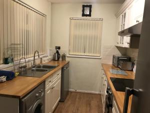 a kitchen with a sink and a dishwasher at Snowdonia miners cottage in Blaenau-Ffestiniog