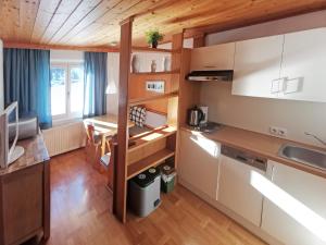 a kitchen with white cabinets and a wooden floor at Ferienwohnungen Kirchweger in Wagrain