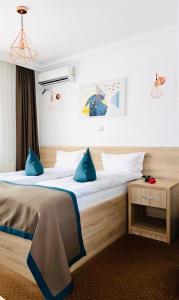 1 dormitorio con 1 cama grande con almohadas azules en Vile Verdi en Baile Felix
