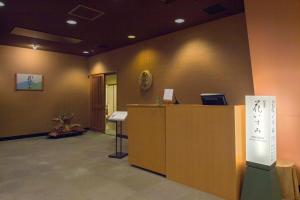 an office with a reception desk and a sign on the wall at Izumigo AMBIENT Azumino Hotel in Azumino