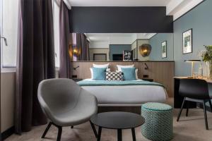 a bedroom with a bed and a desk and a chair at Hôtel Opéra Liège in Paris