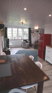 a kitchen with a wooden table and a red refrigerator at Ferienwohnung Diekblick - Kleiner Deichhof in Hattstedtermarsch