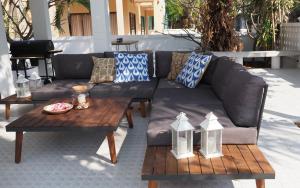 - un canapé et une table basse sur la terrasse dans l'établissement Rayong Beach House, à Ban Bang Nok