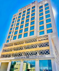 un grand bâtiment blanc avec un panneau sur celui-ci dans l'établissement Mirnian Hotel, à Djeddah