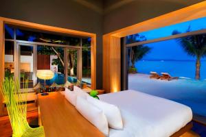 a bedroom with a white bed and a large window at W Koh Samui in Mae Nam