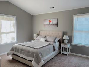 a bedroom with a large bed and two windows at __Kristian’s Palace Your Beach Getaway in Kill Devil Hills