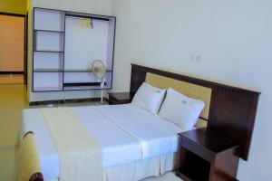 una camera da letto con un letto grande e una finestra di GNS Hotel Kampala a Kampala Altre 37 foto