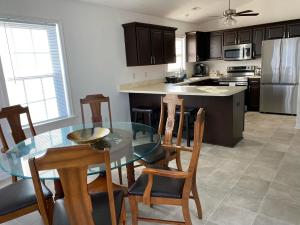 a kitchen with a glass table and wooden chairs at __Kristian’s Palace Your Beach Getaway in Kill Devil Hills