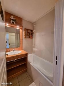 een badkamer met een bad, een wastafel en een douche bij Appartement T2-5 couchages L'écrin des Orres 1800 in Les Orres