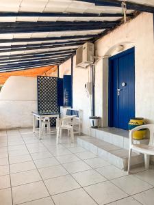 a patio with chairs and a blue door at Sea View Studio Armenistis Ikarias in Armenistis