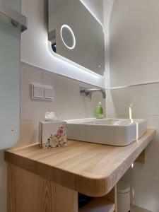 uma casa de banho com um lavatório branco e um espelho. em Ferienhaus AUSZEIT em Crottendorf