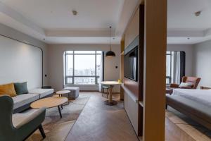 a room with a bed and a living room with a couch at Holiday Inn Chongqing Guanyinqiao by IHG in Chongqing +59 photos