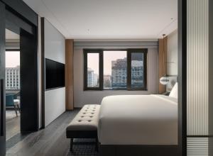 sypialnia z białym łóżkiem i dużym oknem w obiekcie Empark Prime Hotel Beijing w Pekinie