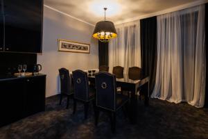 a dining room with a table and chairs and a chandelier at Termy Warmińskie in Lidzbark Warmiński