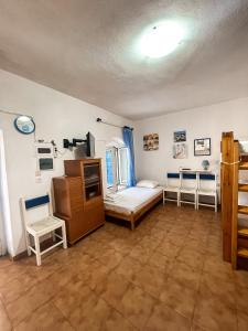 Sea View Studio Armenistis Ikarias في أرمينيستيس: غرفة نوم فيها سرير وكرسيين
