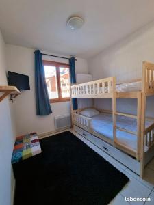 a bedroom with two bunk beds and a window at Appartement T2-5 couchages L'écrin des Orres 1800 in Les Orres