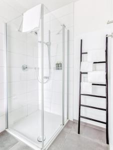 a shower with a glass door in a bathroom at limehome Augsburg Am Katzenstadel in Augsburg