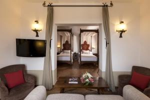 a living room with two beds and a tv at Parador de Tortosa in Tortosa