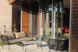 a patio with a couch and chairs and a table at 100% Relax avec Jacuzzi Privatif in Sarlat-la-Canéda