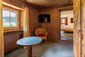 a small room with a table and a tv at Hotel Chesa Pool in Sils Maria