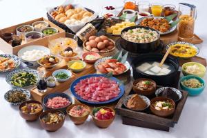a table topped with lots of different types of food at Vessel Inn Ueno Iriya Ekimae in Tokyo