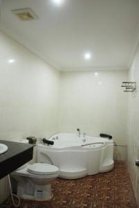 y baño con bañera, aseo y lavamanos. en Emerald BB Battambang Hotel, en Battambang