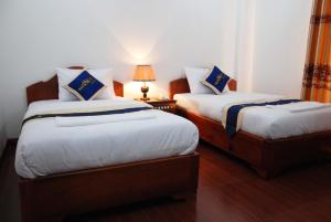 Postel nebo postele na pokoji v ubytování Emerald BB Battambang Hotel