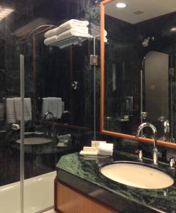 La salle de bains est pourvue d'un lavabo, d'une baignoire et d'un miroir. dans l'établissement Trident Jaipur, à Jaipur