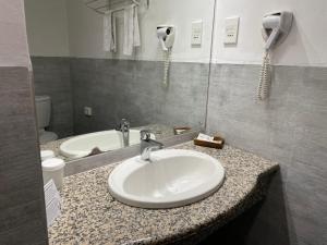 a bathroom counter with a sink and a mirror at Hotel 2001 in Maputo