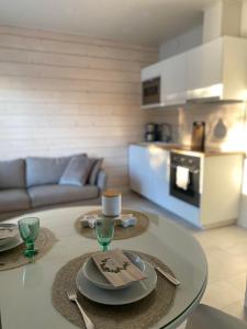 un soggiorno con tavolo in vetro con piatti di Ihana asunto - The Nest with Sauna in VAASA a Vaasa
