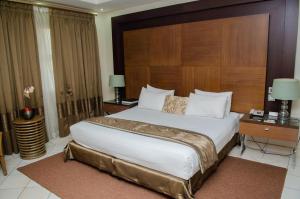 um quarto com uma cama grande com cabeceira de madeira em Hotel 2001 em Maputo