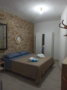 una camera con letto e muro di mattoni di Casa di nonna Marianna a Baunei