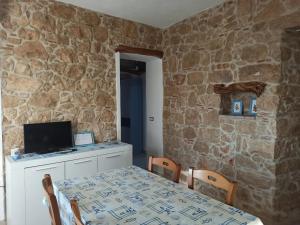 a dining room with a table with a computer on it at Casa di nonna Marianna in Baunei