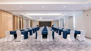 uma sala de conferências com mesas azuis e cadeiras brancas em Holiday Inn Chongqing Guanyinqiao, an IHG Hotel em Chongqing