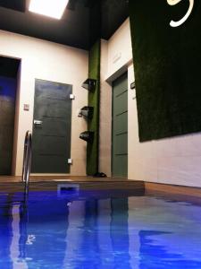 um quarto com uma piscina com uma porta e sapatos em Apartman My Story em Osijek