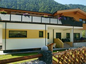 a house in the mountains with a wooden fence at Apartment Ingrid - FUC170 by Interhome in Fusch an der Glocknerstraße