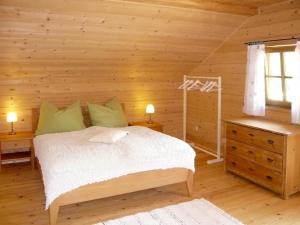 a bedroom with a bed in a log cabin at Holiday Home Lehner im Wald - RZM100 by Interhome in Rutzenmoos
