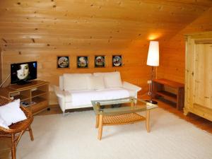 a living room with a white couch and a tv at Holiday Home Lehner im Wald - RZM100 by Interhome in Rutzenmoos