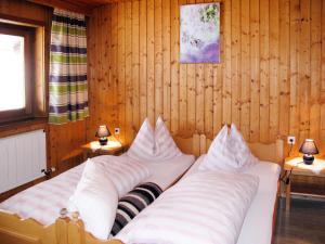 two beds in a room with wooden walls at Holiday Home Moosen - NKI210 by Interhome in Neukirchen am Großvenediger