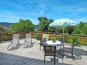 eine Terrasse mit einem Tisch, Stühlen und einem Sonnenschirm in der Unterkunft Holiday Home Mayrhofer - MON240 by Interhome in Oberwang