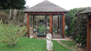 ein kleiner Pavillon mit einer Statue im Gras in der Unterkunft au calme dans Etretat in Étretat