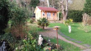 ein kleines Haus in einem Garten mit Statuen im Hof in der Unterkunft au calme dans Etretat in Étretat