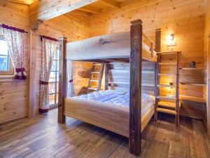 a bedroom with two bunk beds in a log cabin at Chalet Aualm - FRT101 by Interhome in Forstau