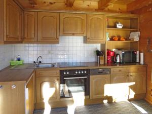a kitchen with wooden cabinets and a stove top oven at Apartment Geislhof - BMG195 by Interhome in Bramberg am Wildkogel