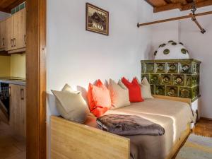 ein Zimmer mit einem Bett mit bunten Kissen darauf in der Unterkunft Holiday Home Glatzbichl - WRF120 by Interhome in Pfarrwerfen