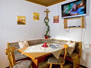 ein Wohnzimmer mit einem Tisch und einem TV in der Unterkunft Holiday Home Glatzbichl - WRF120 by Interhome in Pfarrwerfen
