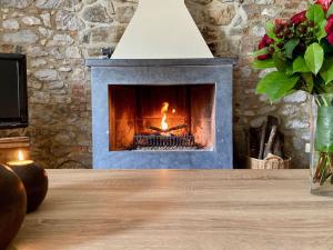 a fireplace in a living room with a wooden table at Holiday Home La Bastide by Interhome in Thy-le-Bauduin