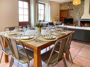 een houten tafel met stoelen en een eetkamer bij Holiday Home La Bastide by Interhome in Thy-le-Bauduin