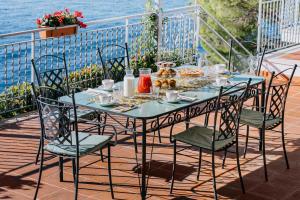 a table with chairs and a table with food on it at Villa Eris Amalfi Coast in Conca dei Marini